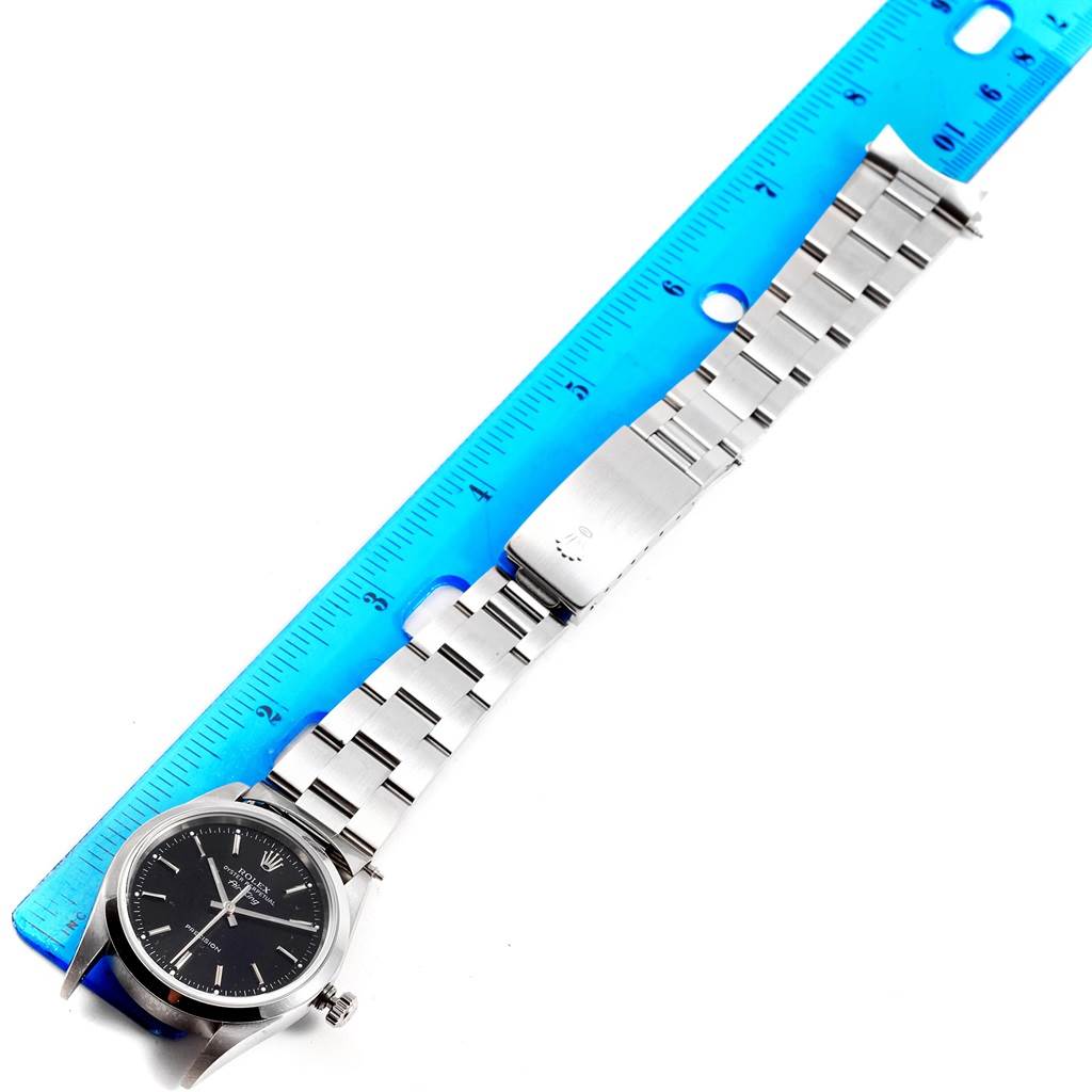 The Rolex Air-King 14000 Men's Stainless Steel Black Dial 14000 Men's Stainless Steel Black Dial watch is shown from the front, displaying the face, bracelet, and clasp, measured against a blue ruler.