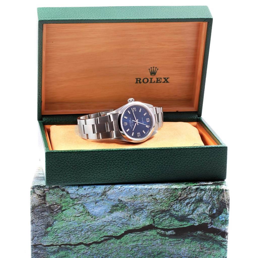 The Rolex Air-King 14000 Men's Stainless Steel Blue Dial 14000 Men's Stainless Steel Blue Dial watch is displayed sitting inside an opened green and tan Rolex box, showing its face and bracelet.