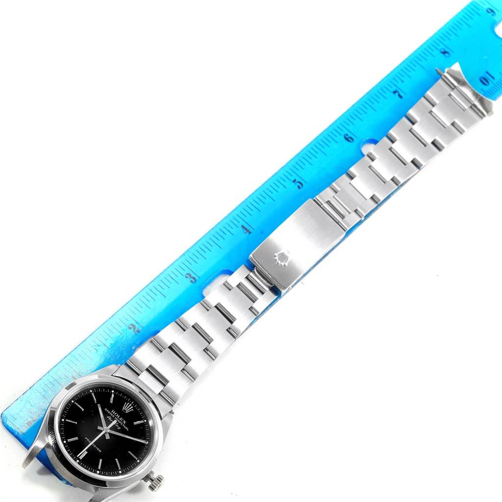 The image shows an overhead view of a Rolex Air-King 14000 Men's Stainless Steel Black Dial 14000 Men's Stainless Steel Black Dial watch and metal bracelet placed next to a blue ruler.