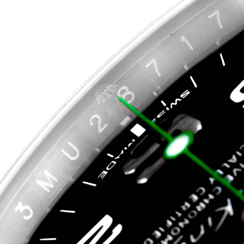 This close-up shot of the Rolex Air-King 116900 Men's Stainless Steel Black Dial 116900 Men's Stainless Steel Black Dial watch shows part of the dial, highlighting numbers and the green second hand.