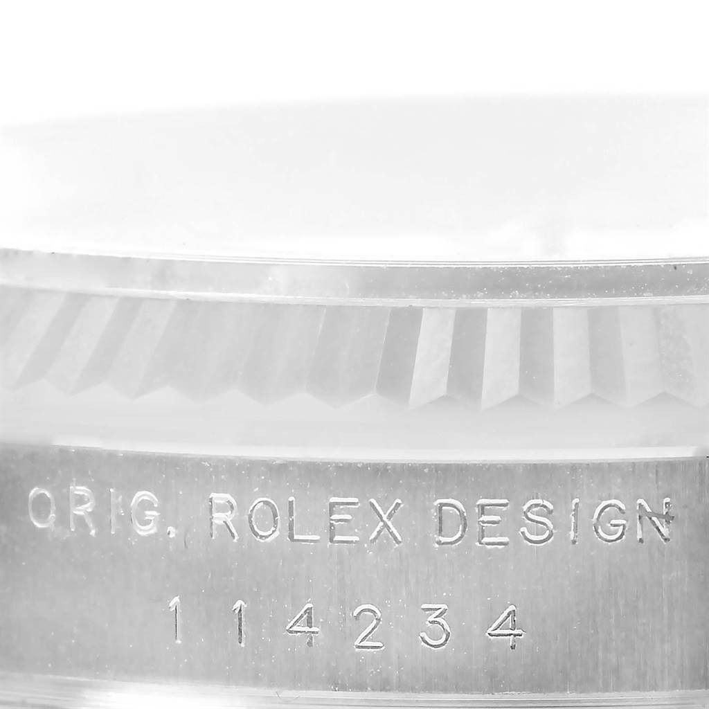 This image shows a close-up of the engraved side of the Rolex Air-King 114234 Men's Stainless Steel Silver Dial 114234 Men's Stainless Steel Silver Dial model's case, displaying "ORIG. ROLEX DESIGN 114234".