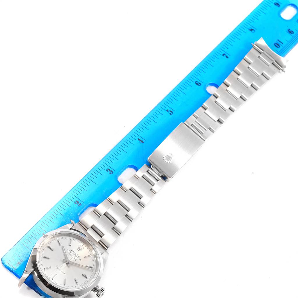 The image shows a Rolex Air-King 14000 Men's Stainless Steel Silver Dial 14000 Men's Stainless Steel Silver Dial watch laid flat with its stainless steel band fully extended next to a blue ruler for measurement.