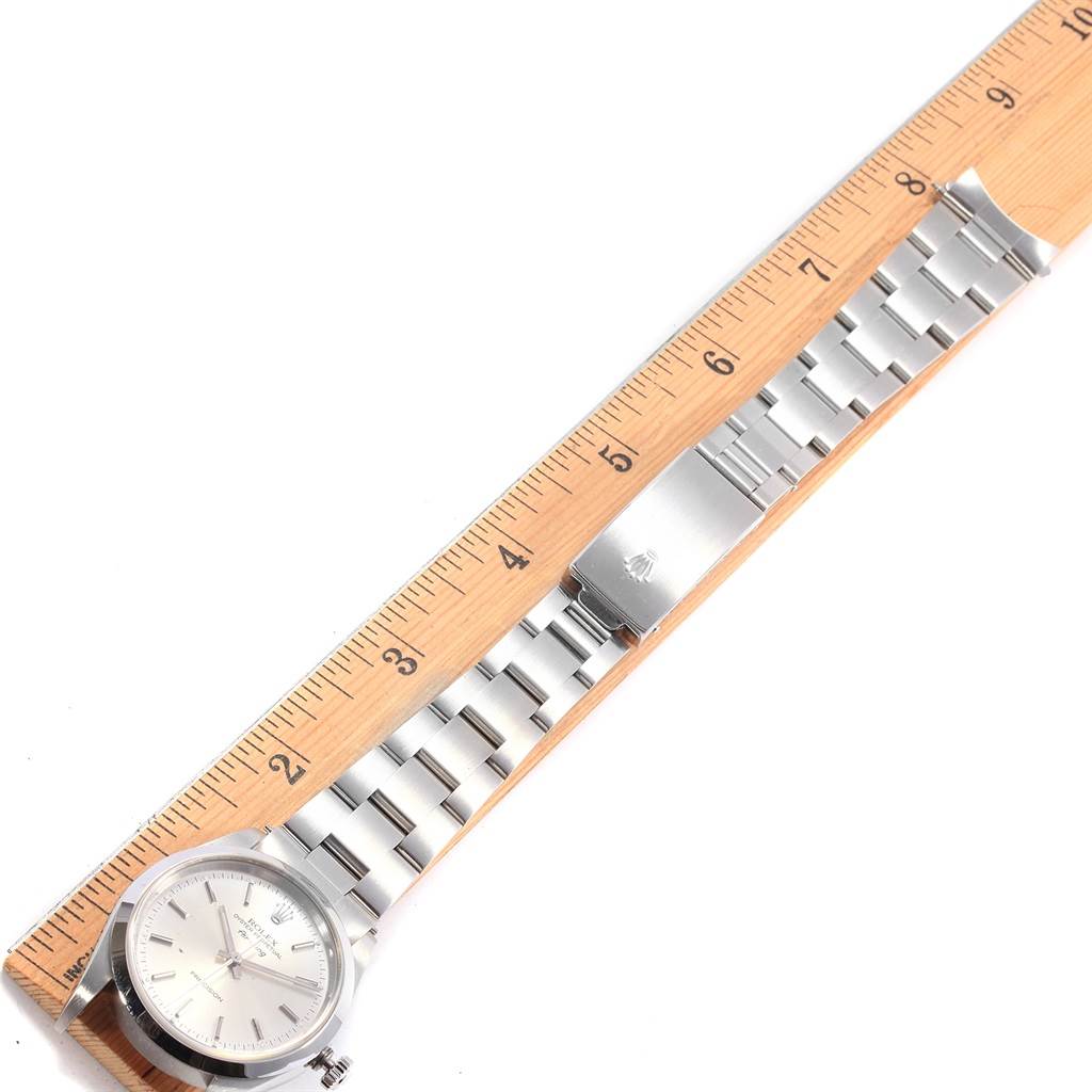 The Air-King model by Rolex is shown in a top-down view displaying the watch face, bracelet, and clasp next to a ruler for scale.