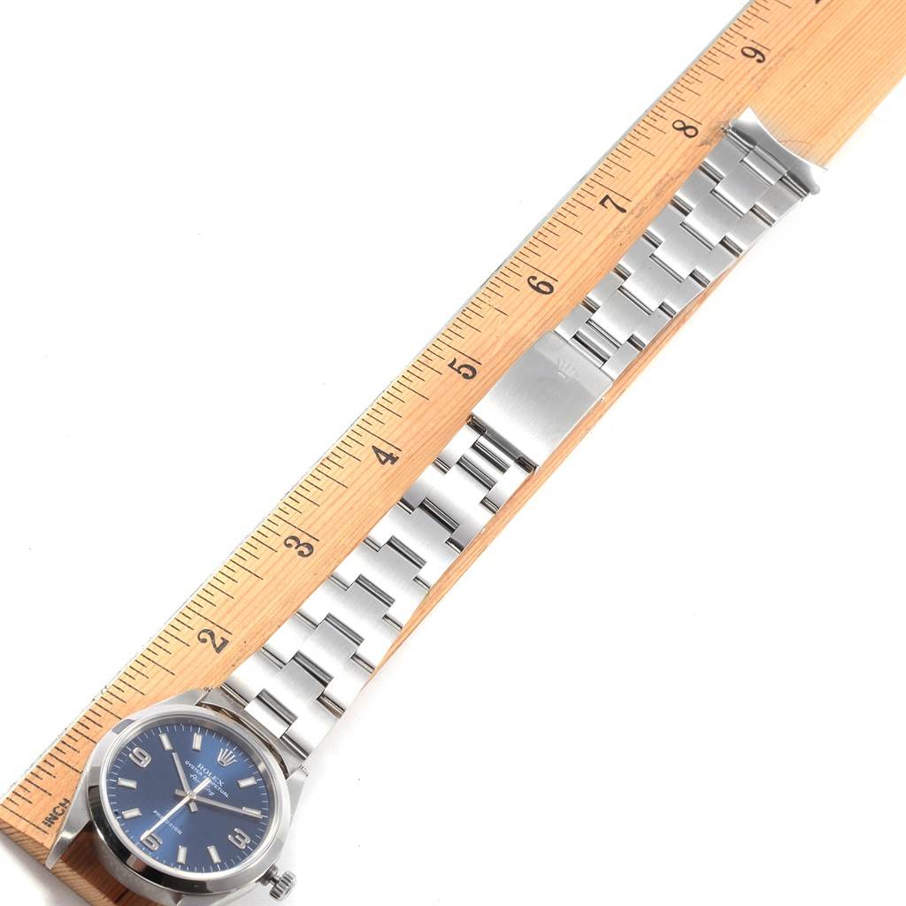 The image shows a Rolex Air-King 14000 Men's Stainless Steel Blue Dial 14000 Men's Stainless Steel Blue Dial watch laying flat next to a wooden ruler, displaying the watch face and its silver bracelet.