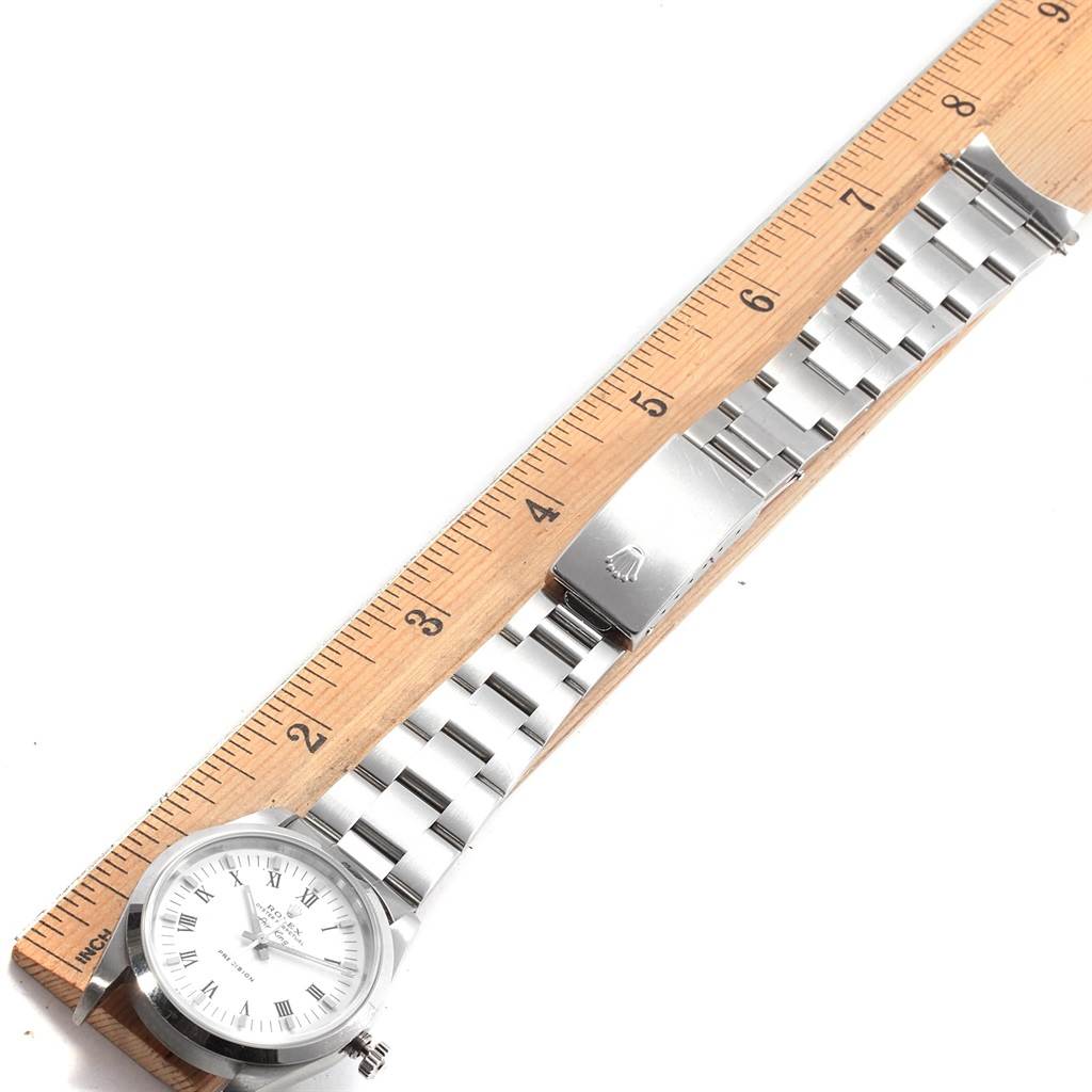 This image shows the Rolex Air-King 14000 Men's Stainless Steel White Dial 14000 Men's Stainless Steel White Dial watch laid flat with a view of the dial, bracelet, and clasp next to a ruler for scale.