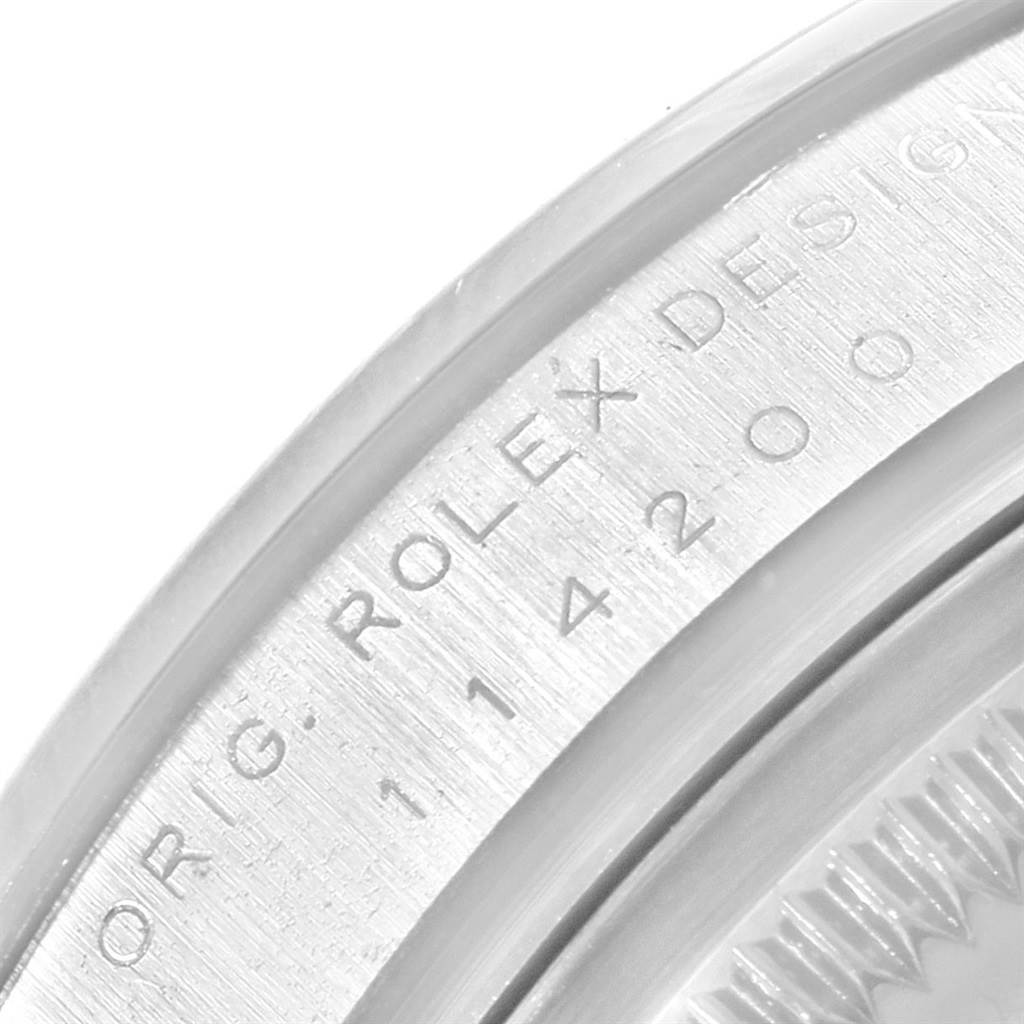 This is a close-up shot of the edge of a Rolex Air-King 114200 Stainless Steel Silver Dial 114200 Stainless Steel Silver Dial watch, showing the "ROLEX DESIGN" engraving.