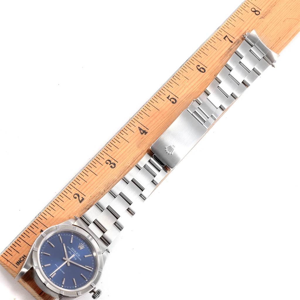 The image shows a Rolex Air-King 14010 Men's Stainless Steel Blue Dial 14010 Men's Stainless Steel Blue Dial watch laid next to a ruler, showcasing the watch face, bracelet, and clasp.