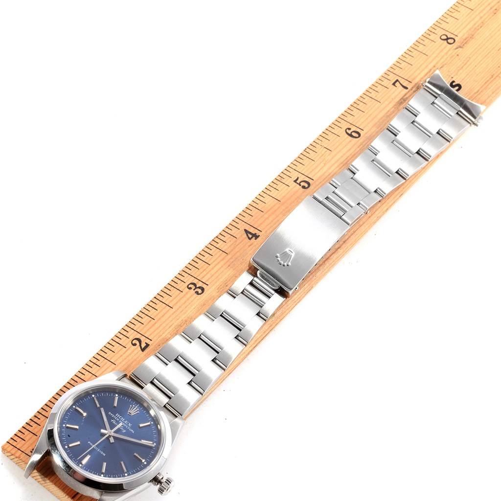 This image shows a top-down view of a Rolex Air-King 14000 Men's Stainless Steel Blue Dial 14000 Men's Stainless Steel Blue Dial watch placed alongside a wooden ruler.