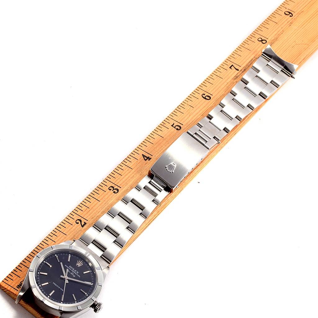 This image shows the Rolex Air-King 14010 Men's Stainless Steel Black Dial 14010 Men's Stainless Steel Black Dial watch lying flat with a ruler to measure its length, displaying the face, bracelet, and clasp.