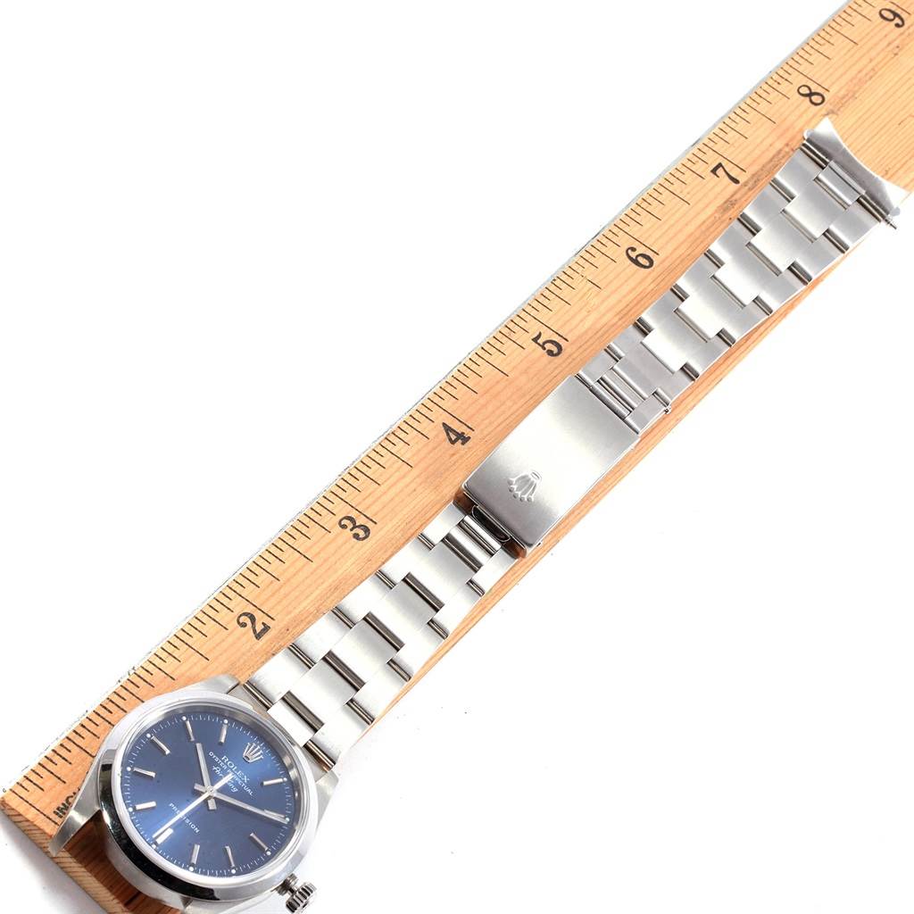 The Rolex Air-King 14000 Men's Stainless Steel Blue Dial 14000 Men's Stainless Steel Blue Dial watch is shown from a top-down angle, alongside a ruler for scale, displaying the face and metal bracelet.