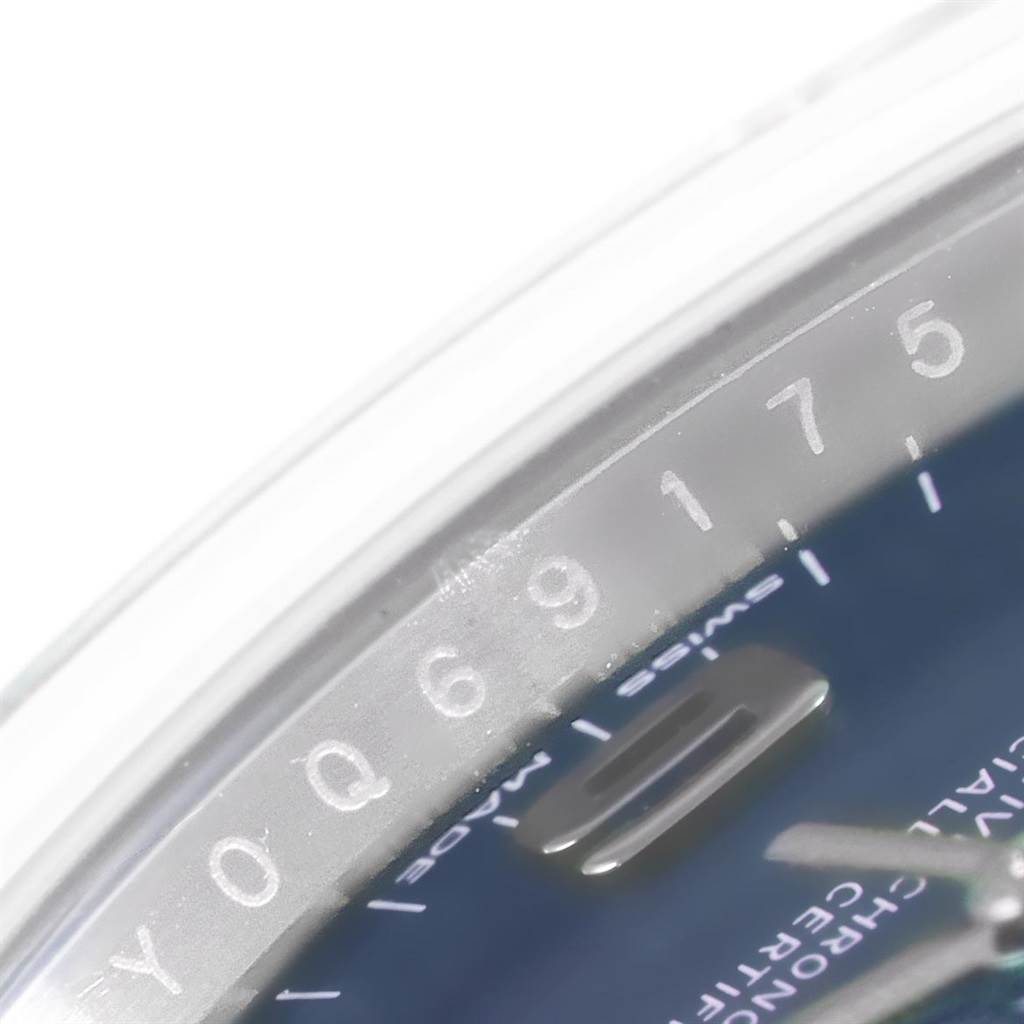 The close-up angled shot of the Rolex Air-King 114200 Men's Stainless Steel Blue Dial 114200 Men's Stainless Steel Blue Dial watch shows part of the dial and the edge of the bezel.