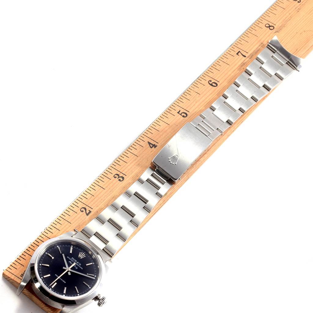 The image shows a Rolex Air-King 14000 Men's Stainless Steel Black Dial 14000 Men's Stainless Steel Black Dial watch taken from a top-down angle, displaying its face, metal bracelet, and clasp, next to a ruler for scale.