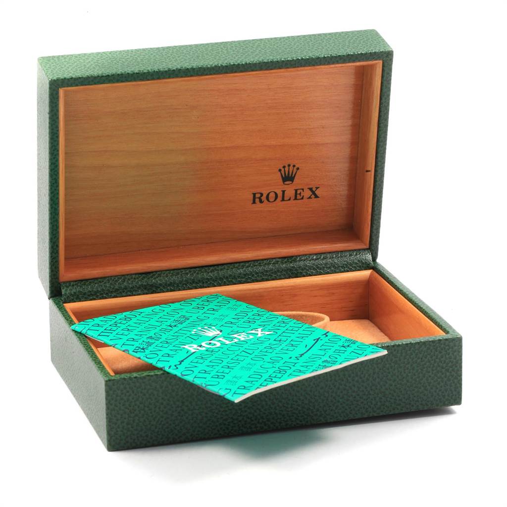 The image shows an open Rolex watch box with a booklet, angled slightly from the front.