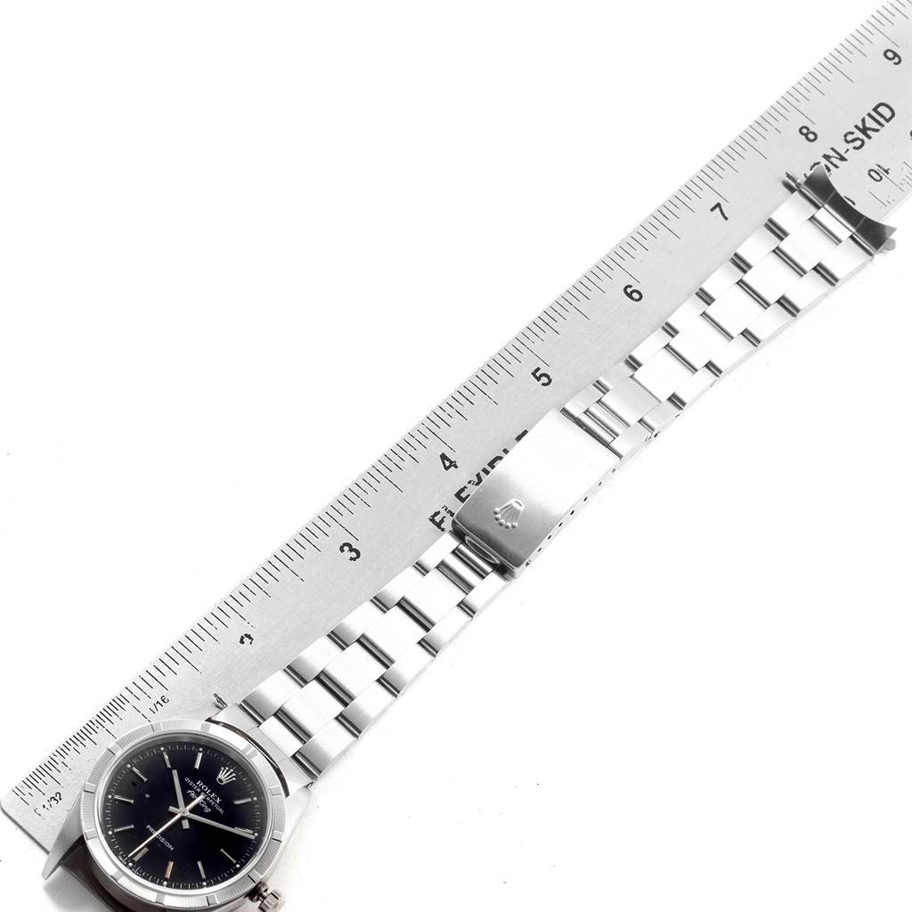The image shows a full side view of a Rolex Air-King 14010 Men's Stainless Steel Black Dial 14010 Men's Stainless Steel Black Dial watch with its stainless steel bracelet and clasp, next to a ruler for scale.
