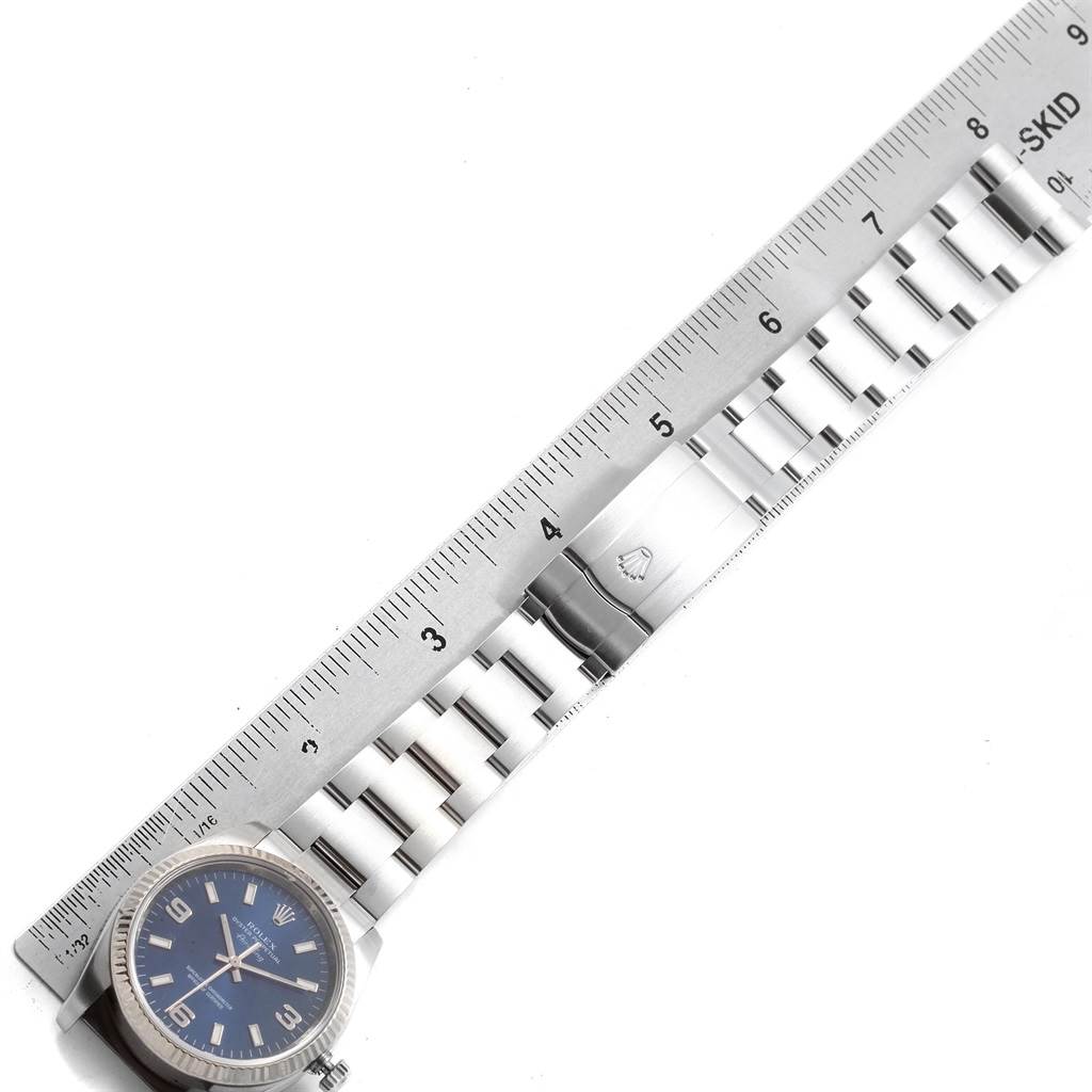 The Rolex Air-King 114234 Men's Stainless Steel Blue Dial 114234 Men's Stainless Steel Blue Dial watch is shown flat, with a focus on the bracelet and clasp, alongside a measuring ruler.