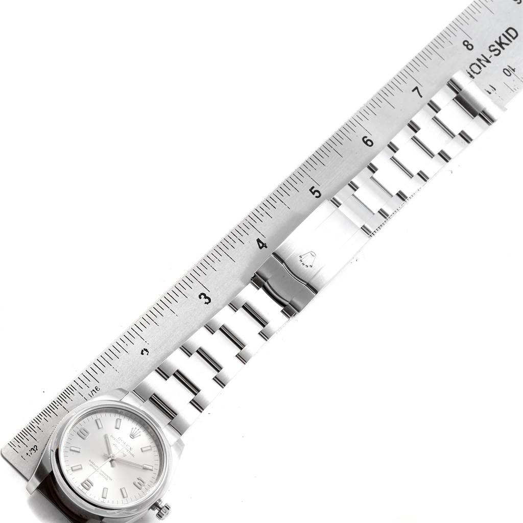 The image shows a top view of a Rolex Air-King 20465 Men's Stainless Steel Silver Dial 20465 Men's Stainless Steel Silver Dial watch with its metal bracelet next to a ruler for measurement.