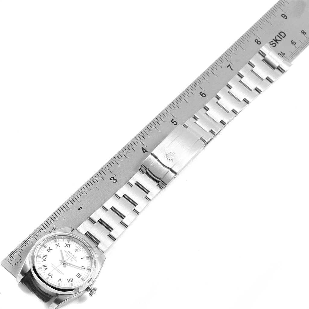 The image shows a top-down view of the Rolex Air-King 114200 Men's Stainless Steel White Dial 114200 Men's Stainless Steel White Dial watch, focusing on the dial, bracelet, and clasp next to a ruler.