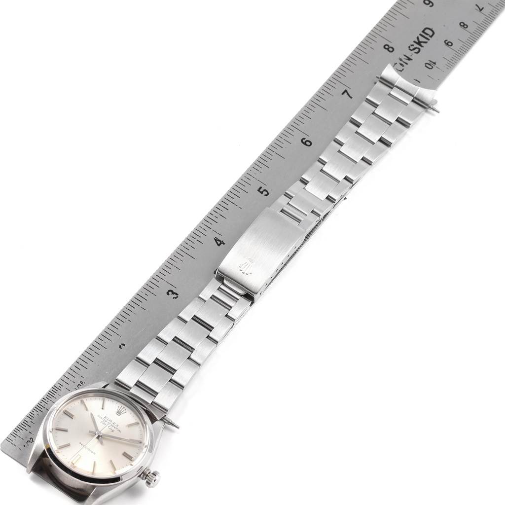 The Rolex Air-King 5500 Men's Stainless Steel Silver Dial 5500 Men's Stainless Steel Silver Dial watch is shown flat with its face and band aligned next to a ruler for measurement.