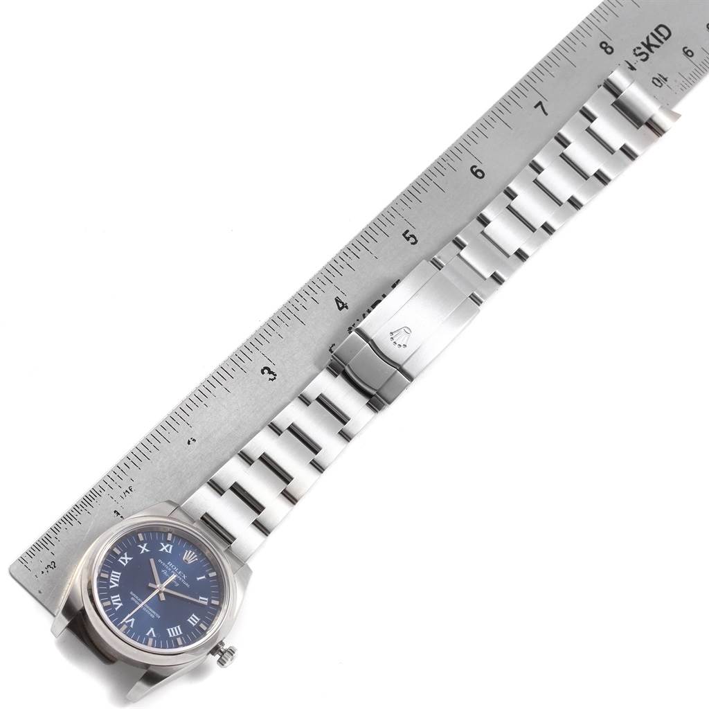 The Rolex Air-King 114200 Men's Stainless Steel Blue Dial 114200 Men's Stainless Steel Blue Dial watch is shown from a top-down angle, displaying its face, bezel, and stainless steel bracelet with a ruler for scale.