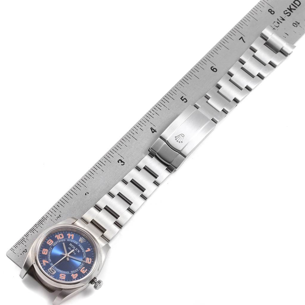 The image shows a Rolex Air-King 114200 Men's Stainless Steel Blue Dial 114200 Men's Stainless Steel Blue Dial watch lying flat with its dial, bracelet, and clasp visible, next to a ruler for scale.