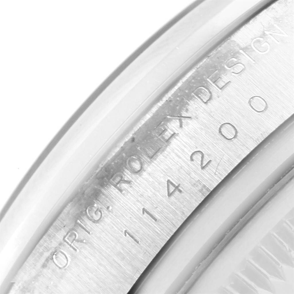 The image shows a close-up of the case side of a Rolex Air-King 114200 Men's Stainless Steel Blue Dial 114200 Men's Stainless Steel Blue Dial watch, highlighting the "ROLEX DESIGN" engraving and model number.