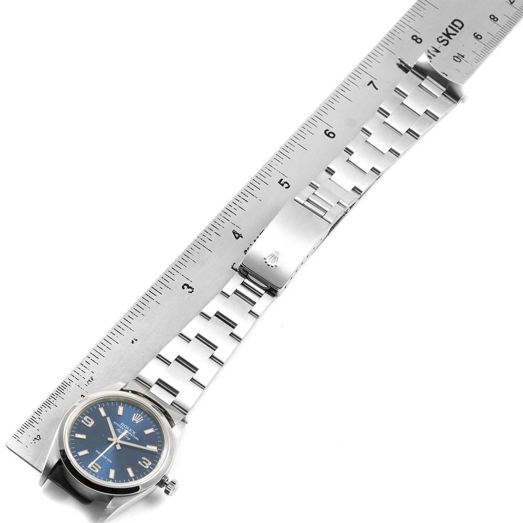 This image shows the face and band of a Rolex Air-King 14000 Men's Stainless Steel Blue Dial 14000 Men's Stainless Steel Blue Dial watch, placed next to a ruler, displaying its measurement.