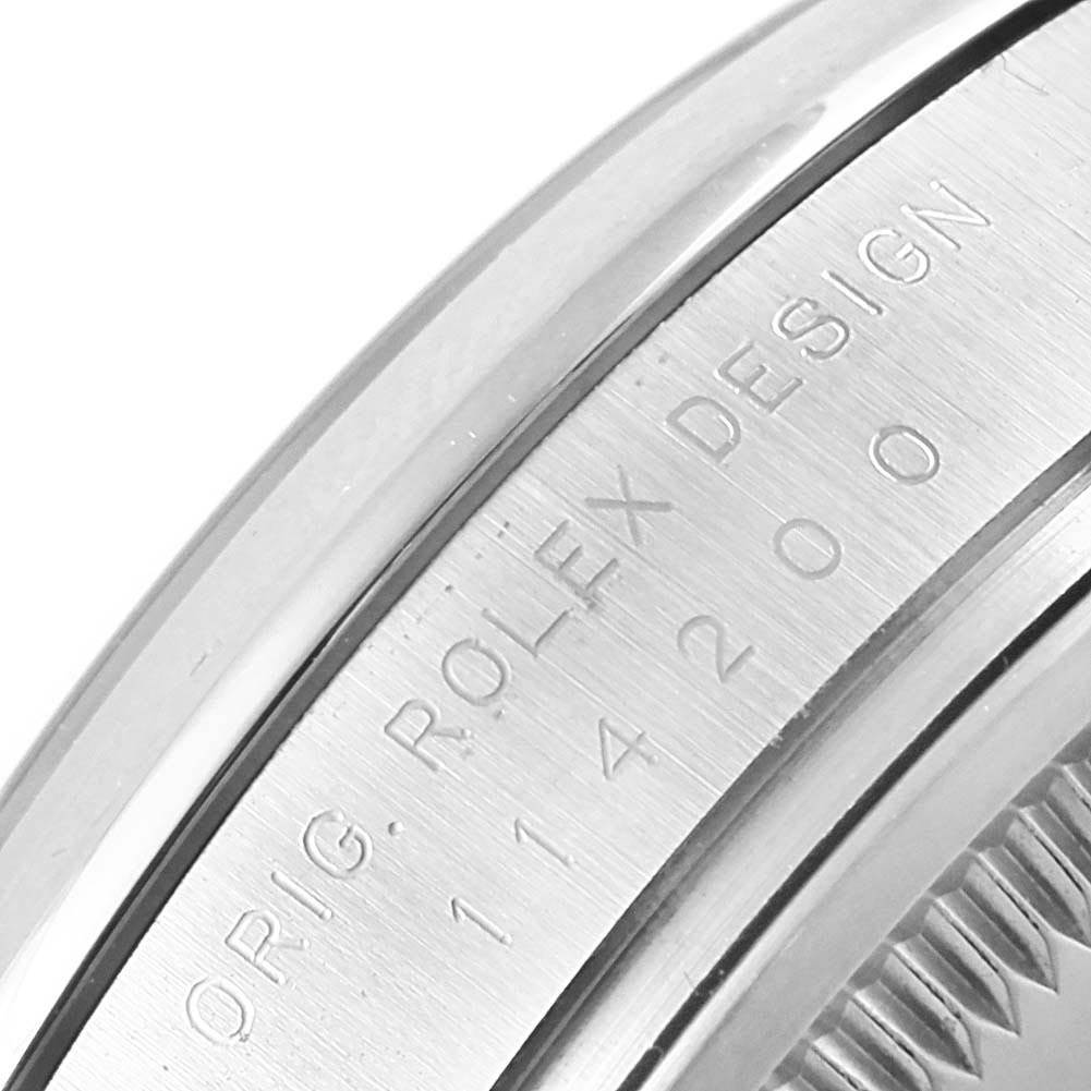 The image shows a close-up of the engraved bezel and case edge of a Rolex Air-King 114200 Men's Stainless Steel White Dial 114200 Men's Stainless Steel White Dial watch.