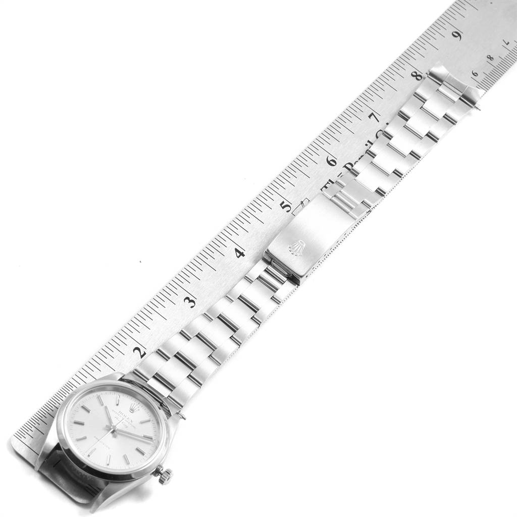 The Rolex Air-King 14000 Men's Stainless Steel Silver Dial 14000 Men's Stainless Steel Silver Dial watch is shown from a top-down angle, displaying the watch face, bracelet, and clasp next to a ruler.