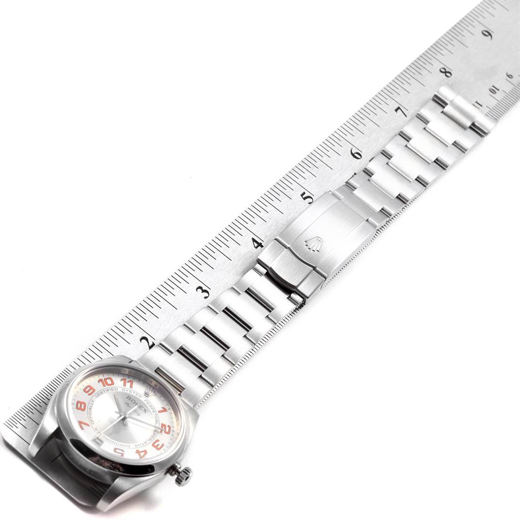 The image shows a side view of a Rolex Air-King 114200 Men's Stainless Steel Silver Dial 114200 Men's Stainless Steel Silver Dial watch and part of its metal strap with a ruler for scale.