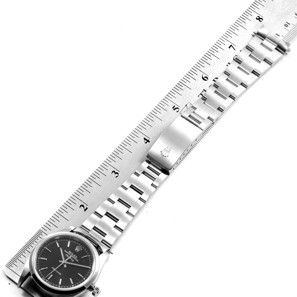The image shows the Rolex Air-King 14000 Men's Stainless Steel Black Dial 14000 Men's Stainless Steel Black Dial watch laid out flat, with a ruler beside it, highlighting its stainless steel bracelet and clasp.
