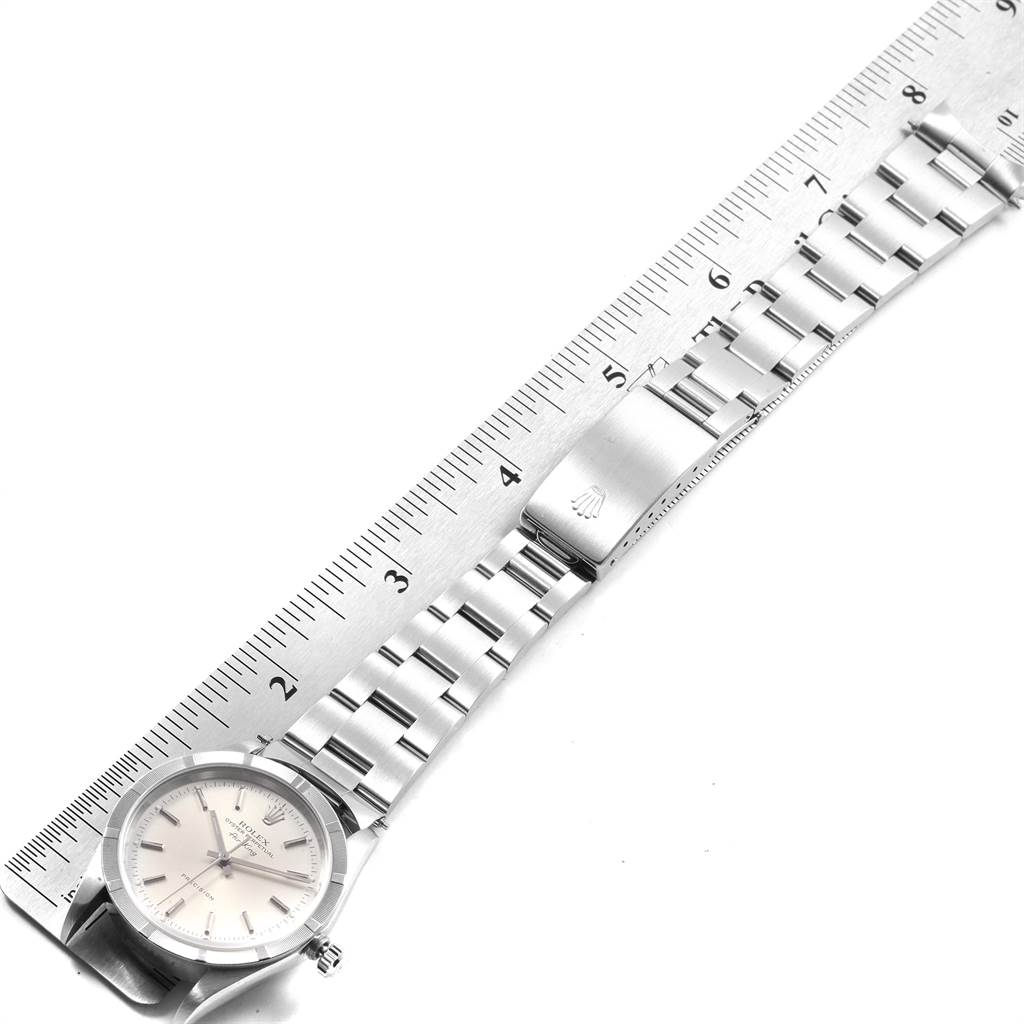 The image shows a side view of the Rolex Air-King 14010 Men's Stainless Steel Silver Dial 14010 Men's Stainless Steel Silver Dial watch, highlighting the dial, clasp, and bracelet alongside a ruler for scale.