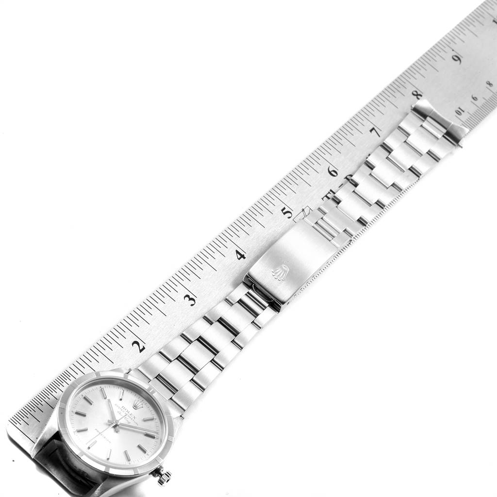 This image shows a top view of a Rolex Air-King 14010 Men's Stainless Steel Silver Dial 14010 Men's Stainless Steel Silver Dial watch, displaying its face, bracelet, and a clasp against a ruler for measurement.