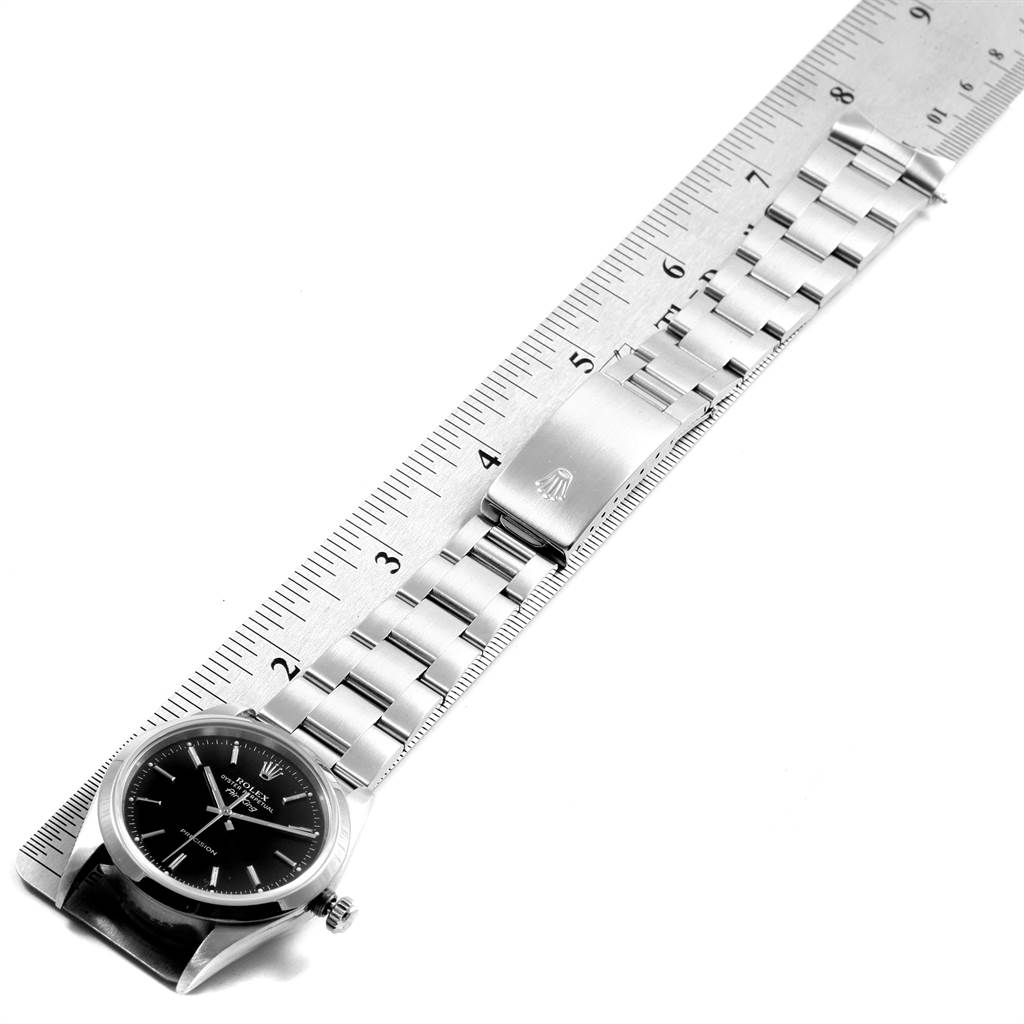 The image shows a top view of a Rolex Air-King 14000 Men's Stainless Steel Black Dial 14000 Men's Stainless Steel Black Dial watch with its bracelet laid alongside a ruler for measurement.