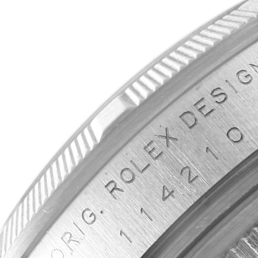 The image shows a close-up of the side of a Rolex Air-King 114210 Men's Stainless Steel Blue Dial 114210 Men's Stainless Steel Blue Dial watch focusing on the engraved model details and fluted bezel.