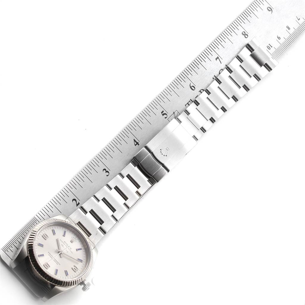 The image shows an aerial view of a Rolex Air-King 114234 Men's Stainless Steel Silver Dial 114234 Men's Stainless Steel Silver Dial watch with a silver strap and a ruler measuring its length.