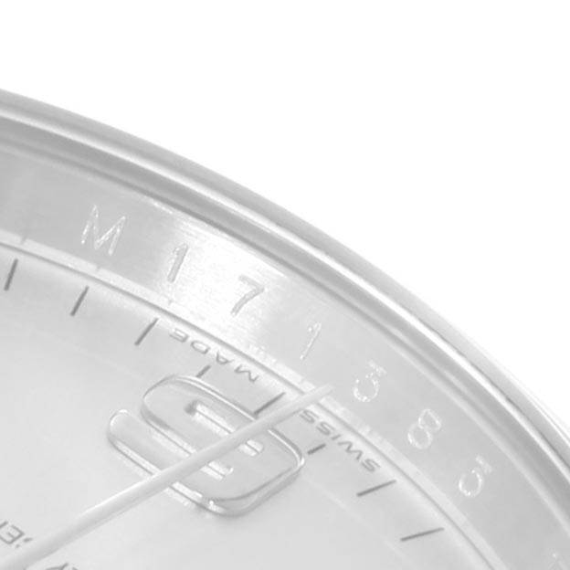 This close-up image of the Rolex Air-King 114200 Men's Stainless Steel Silver Dial 114200 Men's Stainless Steel Silver Dial watch shows the hour markers, part of the dial, and the minute hand.