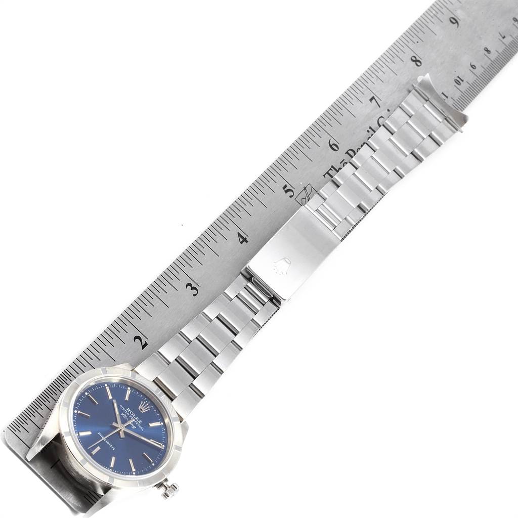 The image shows a Rolex Air-King 14010 Men's Stainless Steel Blue Dial 14010 Men's Stainless Steel Blue Dial watch laid flat with a ruler, capturing the watch face and band.