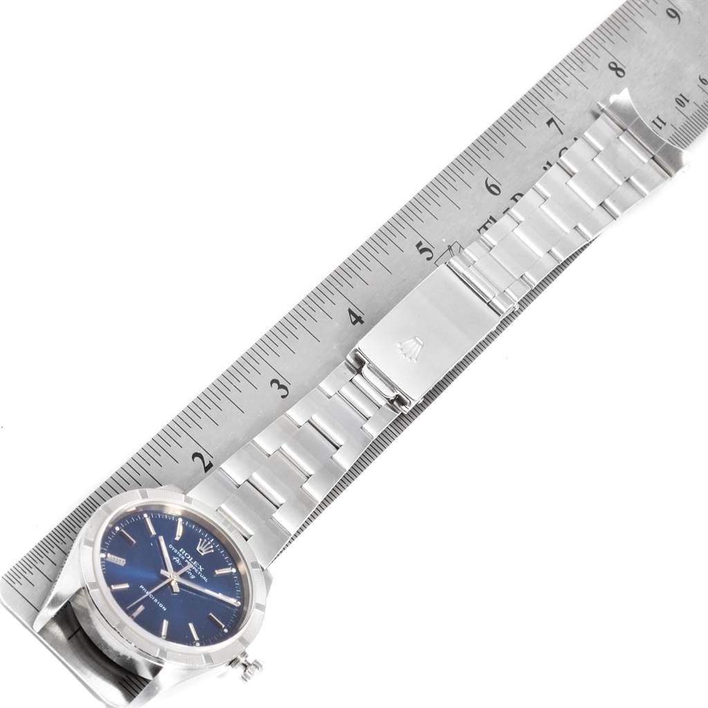 This image shows a Rolex Air-King 14010 Men's Stainless Steel Blue Dial 14010 Men's Stainless Steel Blue Dial watch positioned horizontally beside a ruler, highlighting the watch face and bracelet.