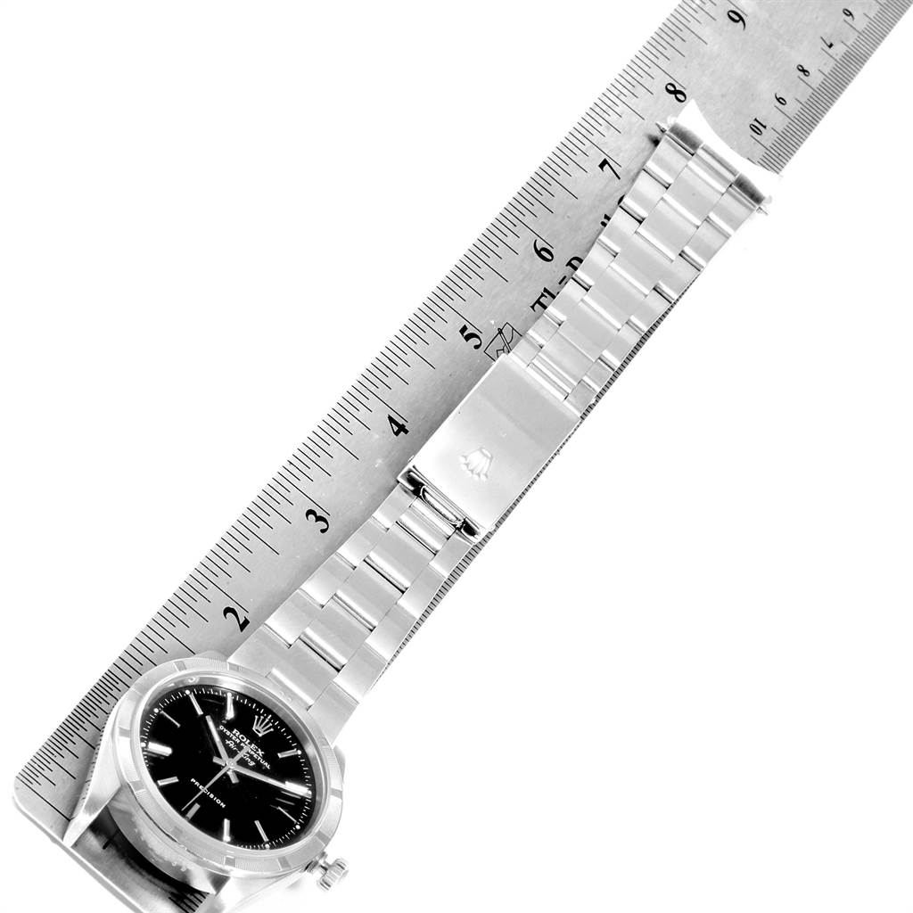 The image shows a Rolex Air-King 14010 Men's Stainless Steel Black Dial 14010 Men's Stainless Steel Black Dial watch with a ruler, featuring its bracelet and dial for size reference.