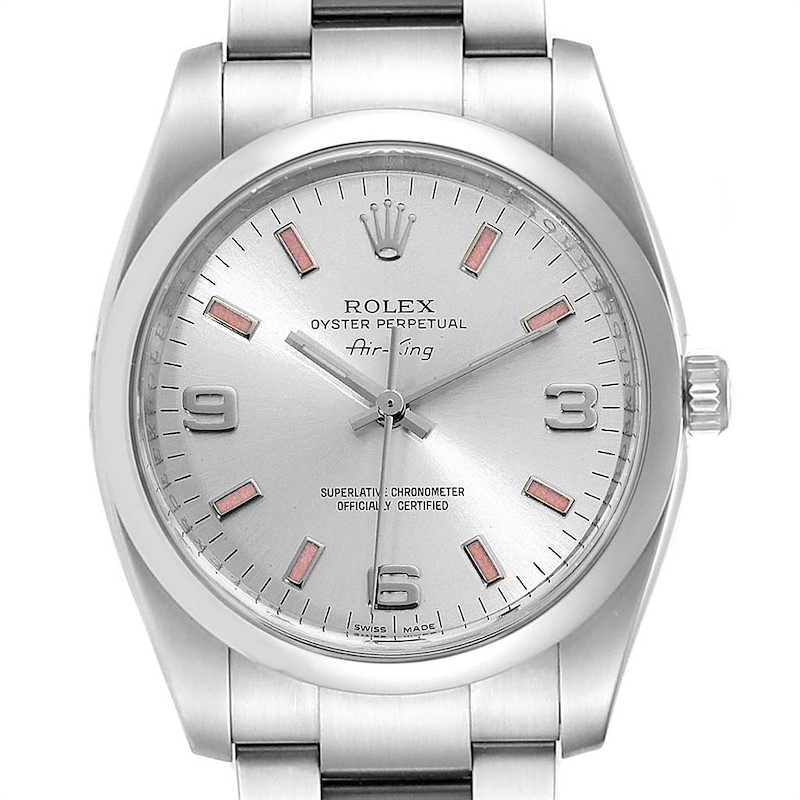 The Rolex Air King 114200 model is shown from a top view, highlighting its silver dial, pink baton markers, and stainless steel bracelet.