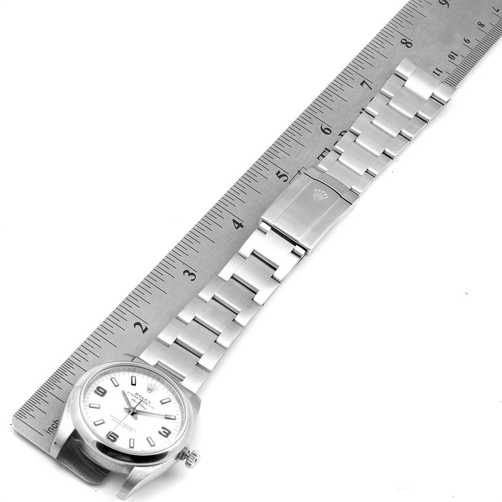The image shows the face and metal bracelet of a Rolex Air-King 114200 Men's Stainless Steel White Dial 114200 Men's Stainless Steel White Dial watch laid next to a ruler for scale.