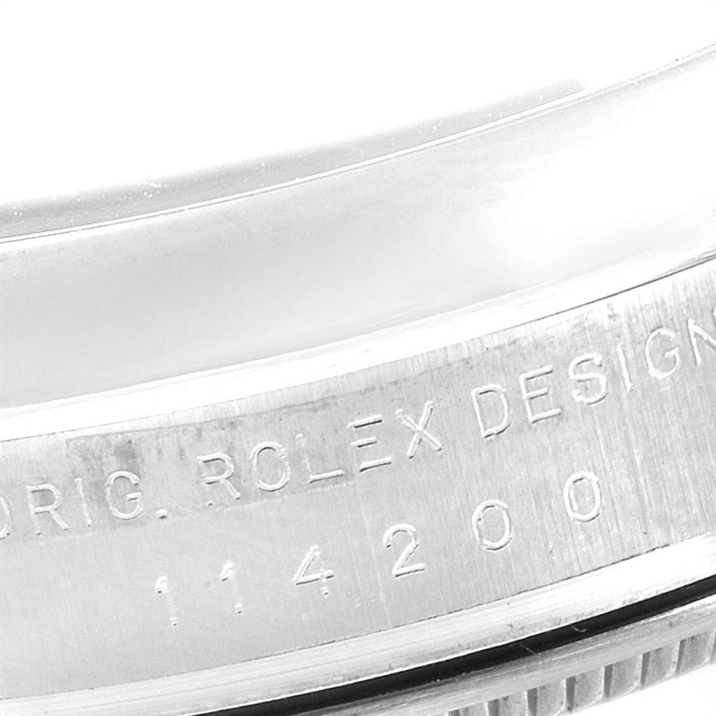 The image shows a close-up of the engraved caseback and bezel of a Rolex Air-King 114200 Men's Stainless Steel Blue Dial 114200 Men's Stainless Steel Blue Dial watch.