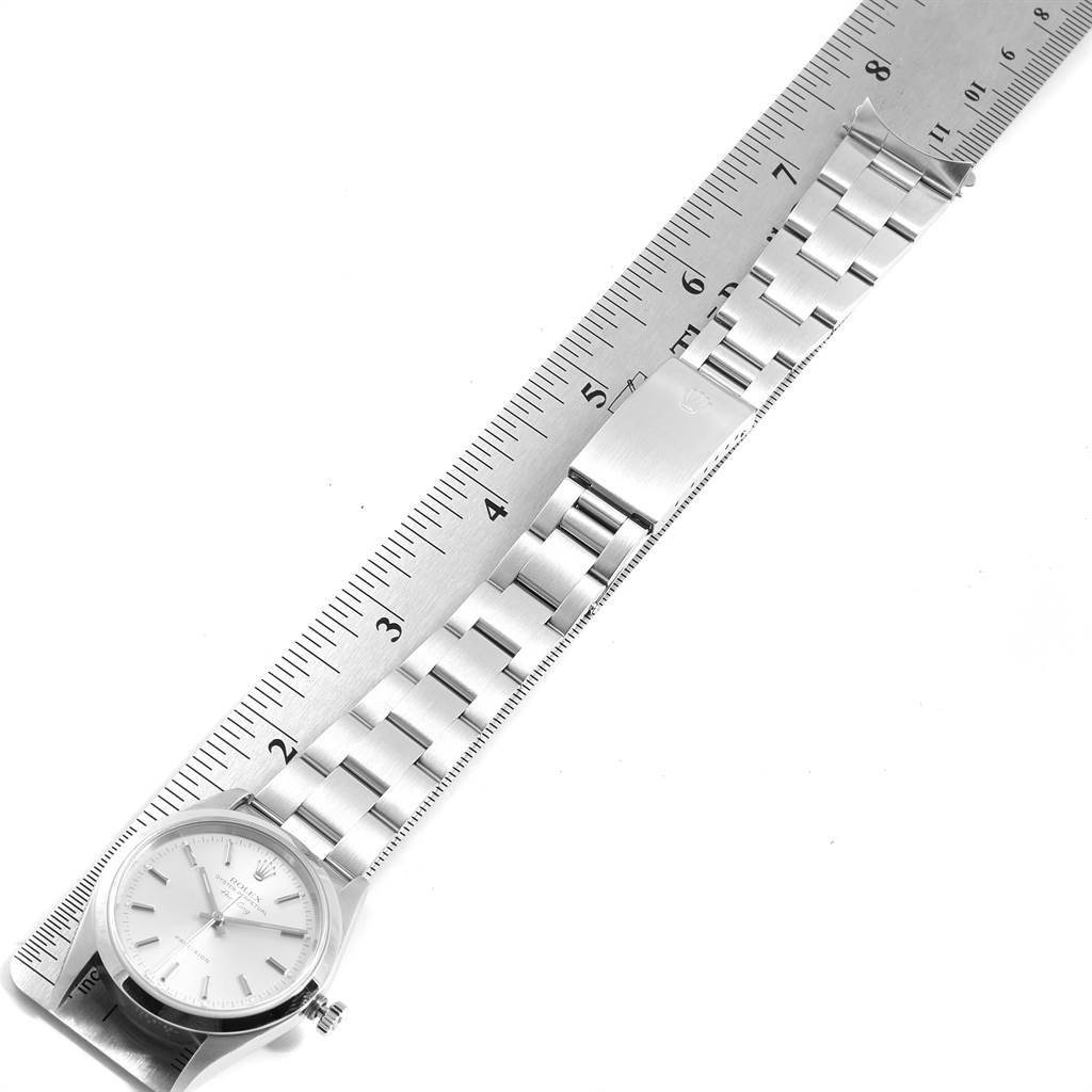 The Rolex Air-King 14000 Men's Stainless Steel Silver Dial 14000 Men's Stainless Steel Silver Dial watch is shown from an overhead angle, including its face, bracelet, and a measuring ruler.
