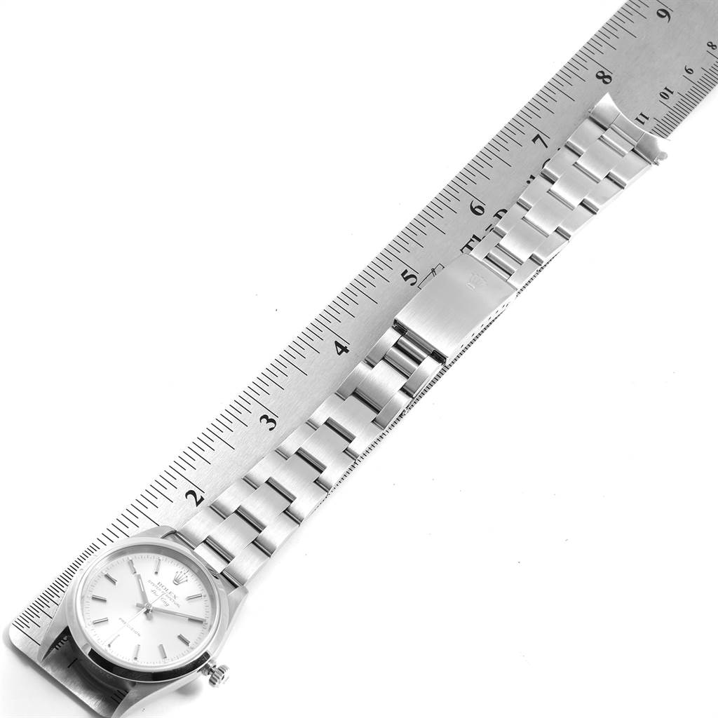 The Rolex Air-King 14000 Men's Stainless Steel Silver Dial 14000 Men's Stainless Steel Silver Dial watch is shown from a top-down angle, displaying its face along with the metal bracelet and clasp laid next to a ruler.