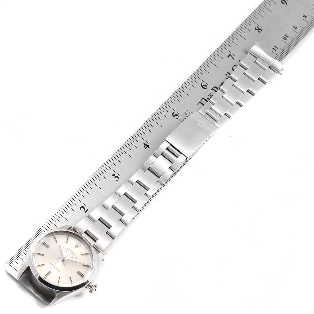The image shows the Rolex Air-King 5500 Men's Stainless Steel Silver Dial 5500 Men's Stainless Steel Silver Dial watch positioned alongside a ruler, highlighting its face and bracelet.