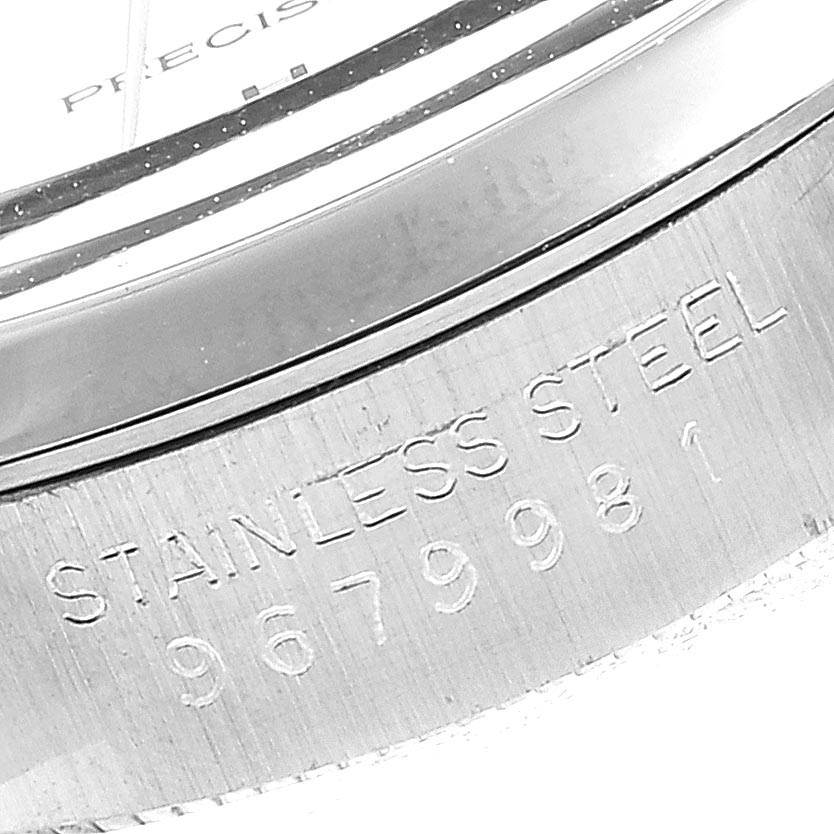 The image shows a close-up of the stainless steel case back and part of the bezel of the Rolex Air-King 5500 Men's Stainless Steel Silver Dial 5500 Men's Stainless Steel Silver Dial watch, featuring engraved text and serial number.
