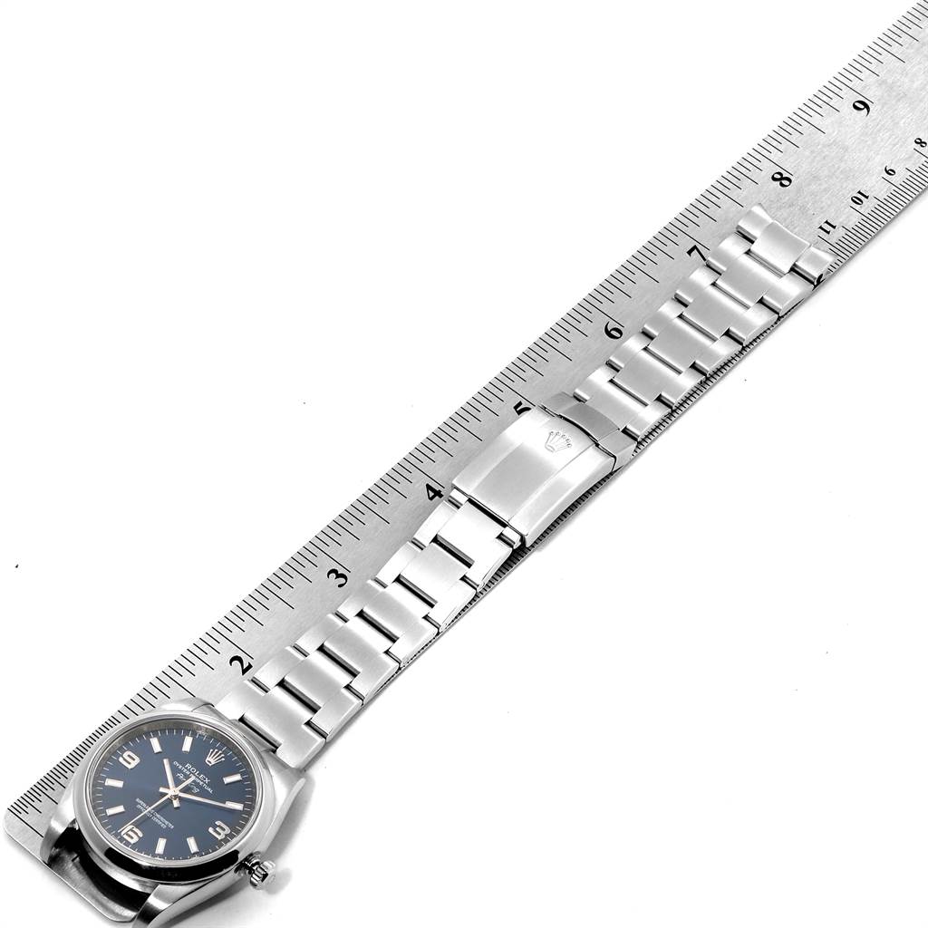 The image shows a Rolex Air-King 114200 Men's Stainless Steel Blue Dial 114200 Men's Stainless Steel Blue Dial watch positioned flat, with the bracelet aligned alongside a ruler for measurement.