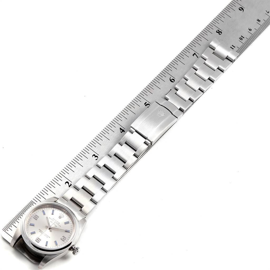 The image shows a top-down view of a Rolex Air-King 114200 Men's Stainless Steel Silver Dial 114200 Men's Stainless Steel Silver Dial watch lying next to a ruler, displaying the watch face and full bracelet.