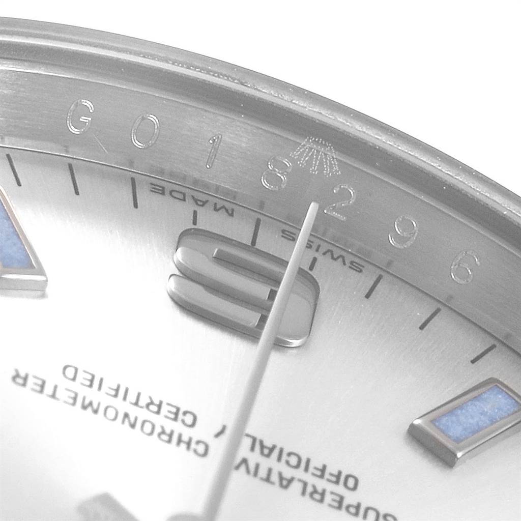 This close-up image of a Rolex Air-King 114200 Men's Stainless Steel Silver Dial 114200 Men's Stainless Steel Silver Dial watch shows part of the dial, including the logo, indices, and part of the hour hand.