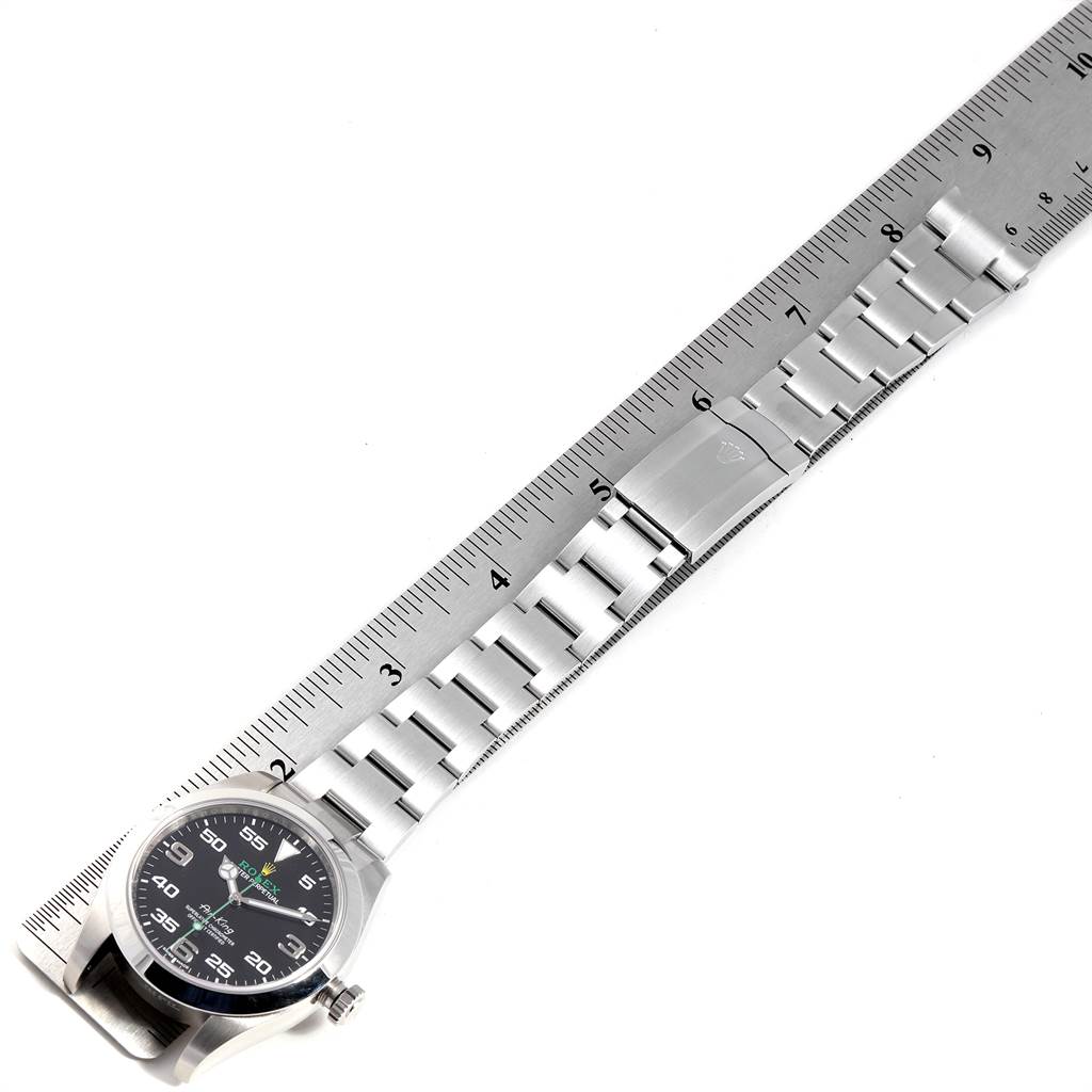 The image shows a side-angle view of a Rolex Air-King 116900 Men's Stainless Steel Black Dial 116900 Men's Stainless Steel Black Dial watch placed alongside a ruler, displaying its bracelet and clasp.
